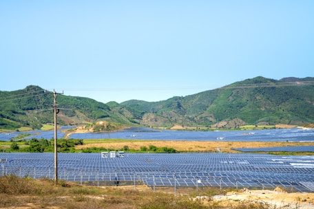 a field of solar panels with mountains in the background