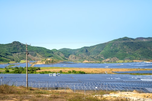 a field of solar panels with mountains in the background