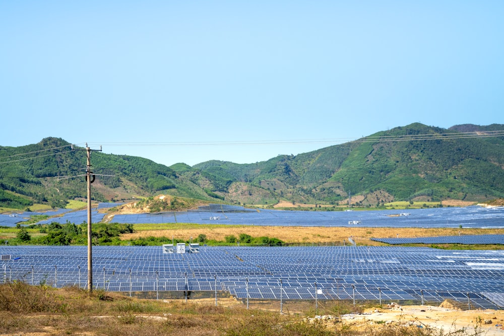 a field of solar panels with mountains in the background