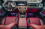 This image depicts the luxurious interior of a high-end car, featuring red leather seats, a sophisticated dashboard with a digital display, a multifunctional steering wheel, and ambient lighting. The design is modern and sleek, emphasizing comfort and style.