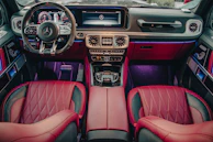 Interior shot showing red leather seats and sleek steering wheel