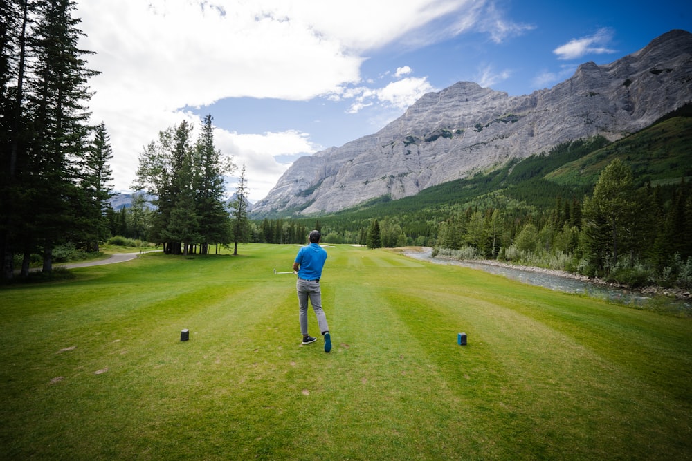 a man standing on top of a lush green field