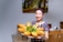 Smiling woman holding a basket of fresh bread in a bakery setting