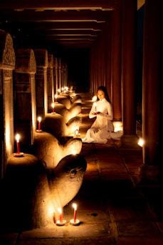 A peaceful scene of a person meditating surrounded by celestial charts and soft candlelight.