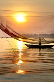 A golden sunrise over Lake Erie with a fishing boat casting nets