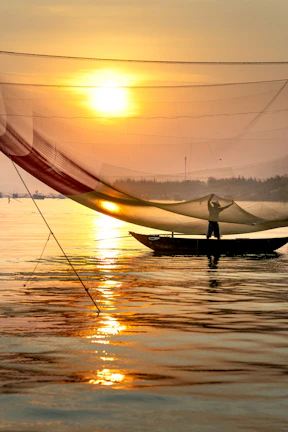 A golden sunrise over Lake Erie with a fishing boat casting nets