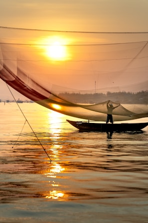 Customer proudly displaying their catch beside their boat at sunset.