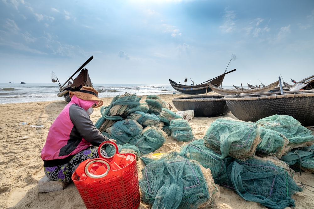 A woman sitting on a beach next to a pile of bags photo – Free Image on  Unsplash