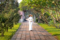 A candid moment of a model walking through a sunlit courtyard, her ethnic dress flowing with the breeze.