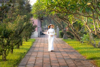A candid moment of a model walking through a sunlit courtyard, her ethnic dress flowing with the breeze.