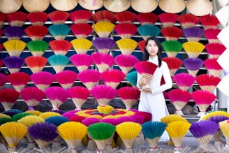 Smiling artisans in traditional attire arranging dhoop cones in neat rows under warm sunlight.