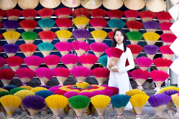 Smiling artisans in traditional attire arranging dhoop cones in neat rows under warm sunlight.