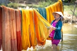 Close-up of a local artisan weaving a colorful fishing net by hand in a rustic workshop