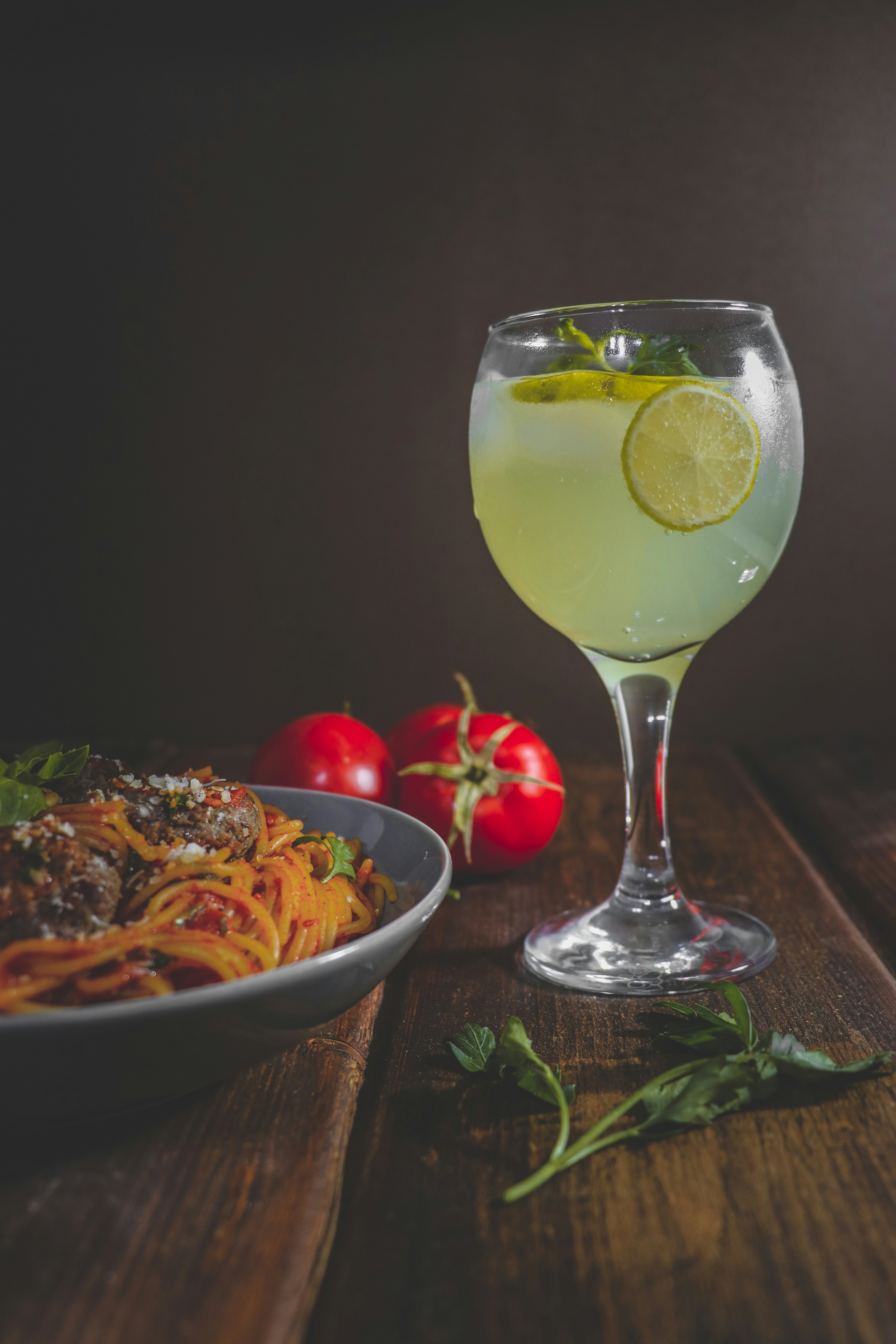 a bowl of pasta and a glass of wine on a table