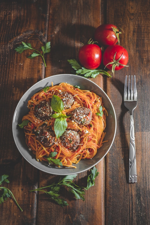 A plate of spaghetti with meatballs and tomatoes