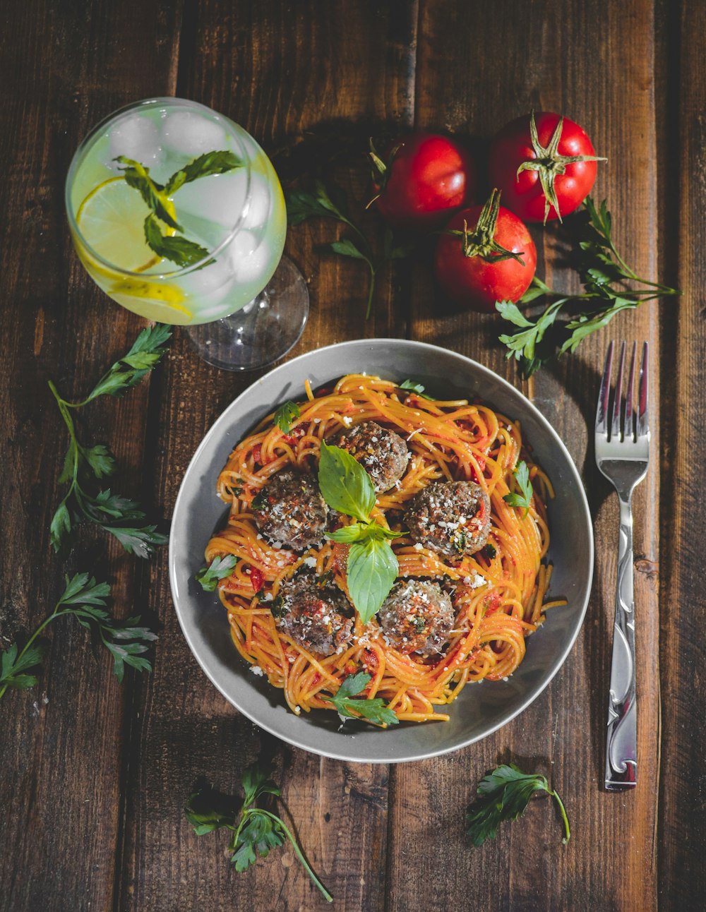 a plate of spaghetti with meatballs and tomatoes