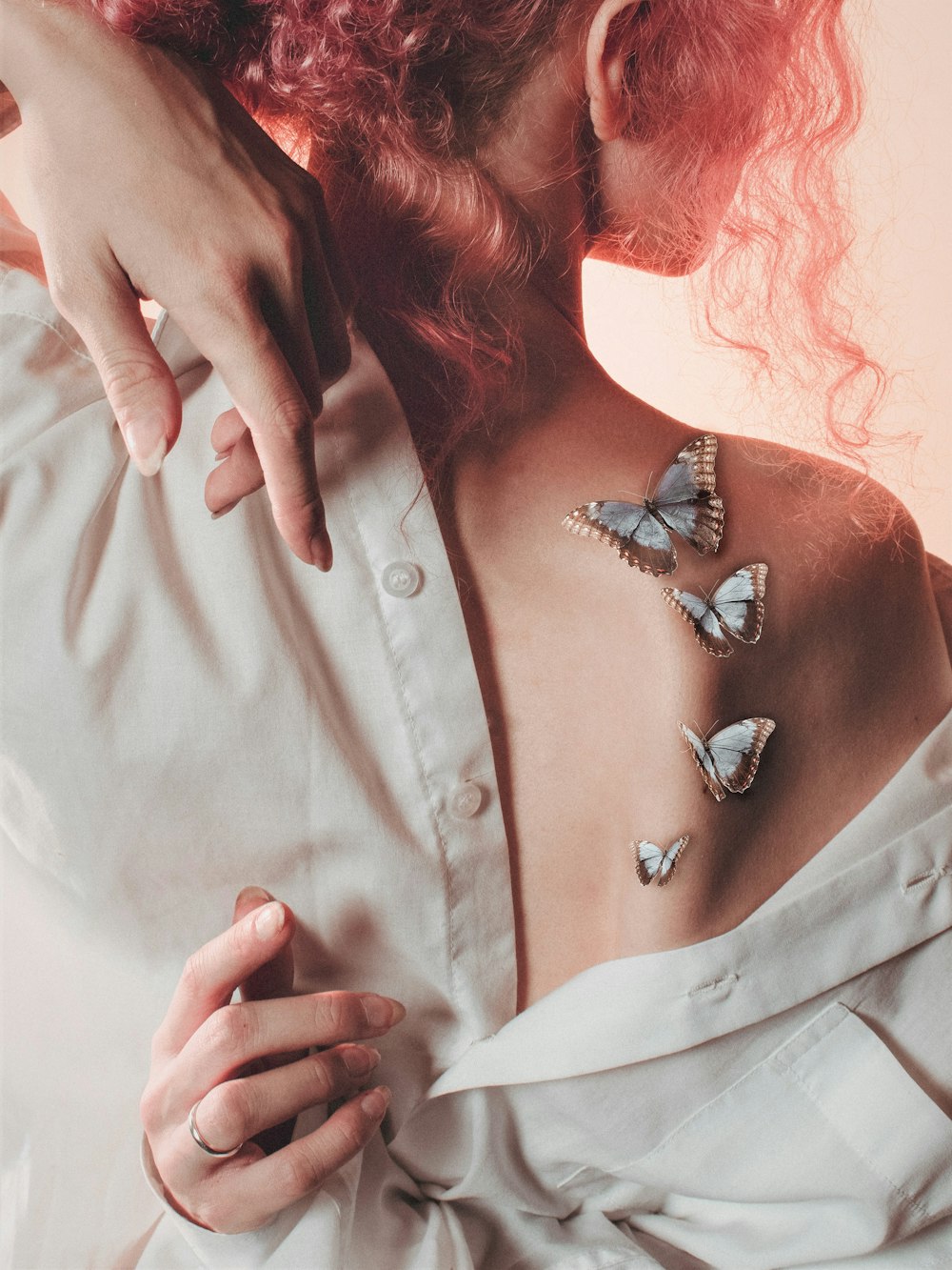 a woman with red hair wearing a white shirt