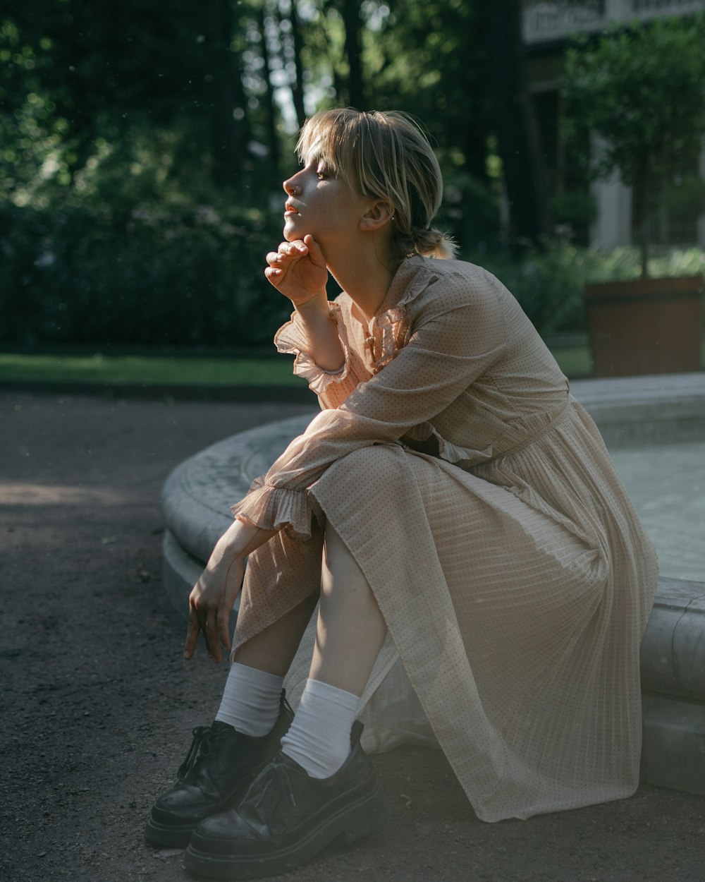 a woman sitting on the ground in a dress