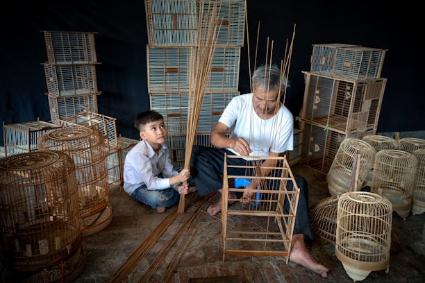 A father and son working together on a handcrafted wooden model in a cozy workshop.