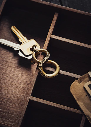 Close-up of a sleek umbrella stand next to a decorative bowl filled with keys and mail.