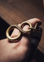 A hand showcasing a beautifully crafted gold ring.