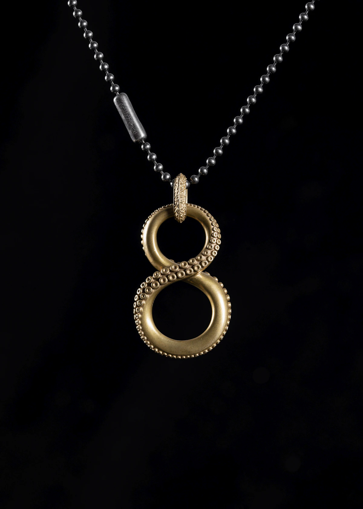Gold pendant necklace on a dark background