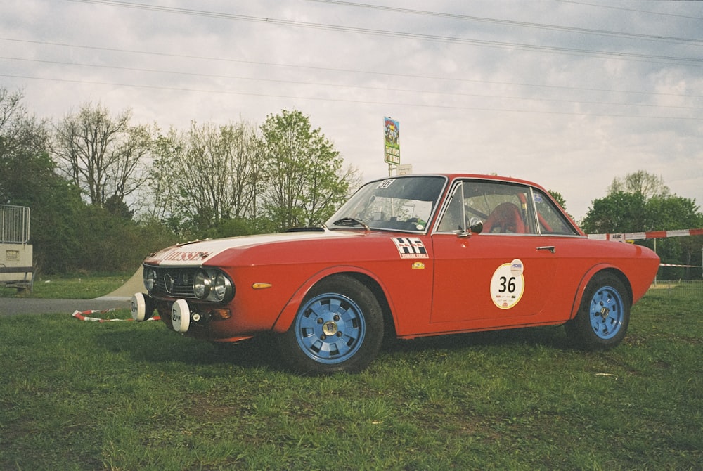 an old race car is parked in the grass