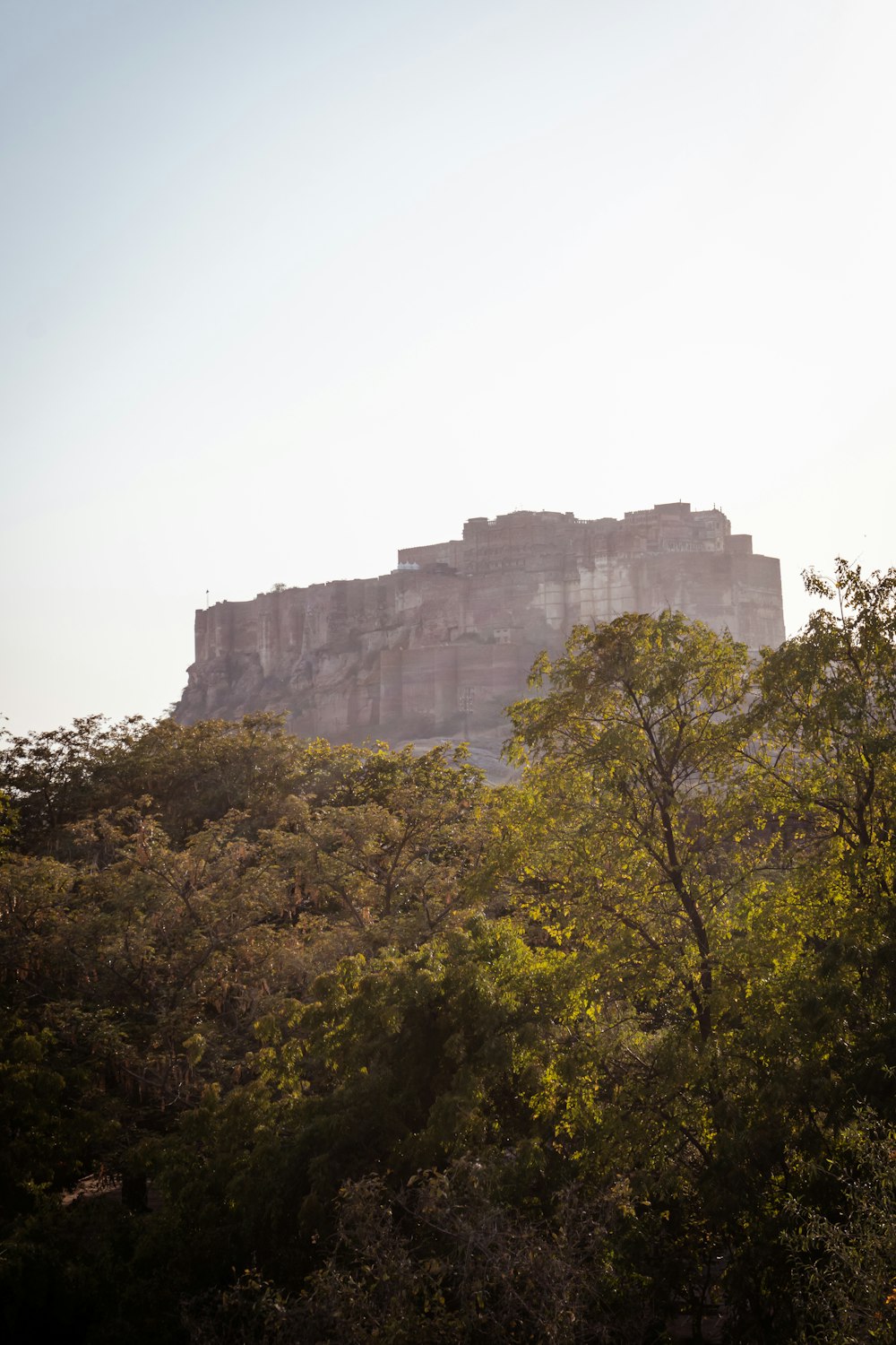 a large stone building sitting on top of a lush green hillside