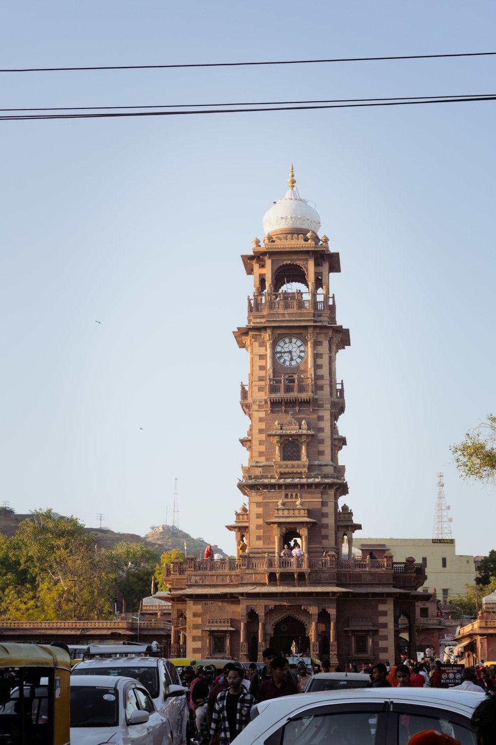 a large clock tower in the middle of a busy street