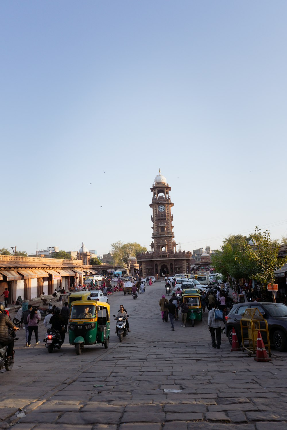 a group of cars parked on a street next to a tall clock tower