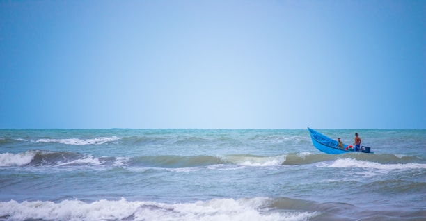 A smiling couple enjoying a serene boat ride on Dal Lake in Kashmir under a clear blue sky.