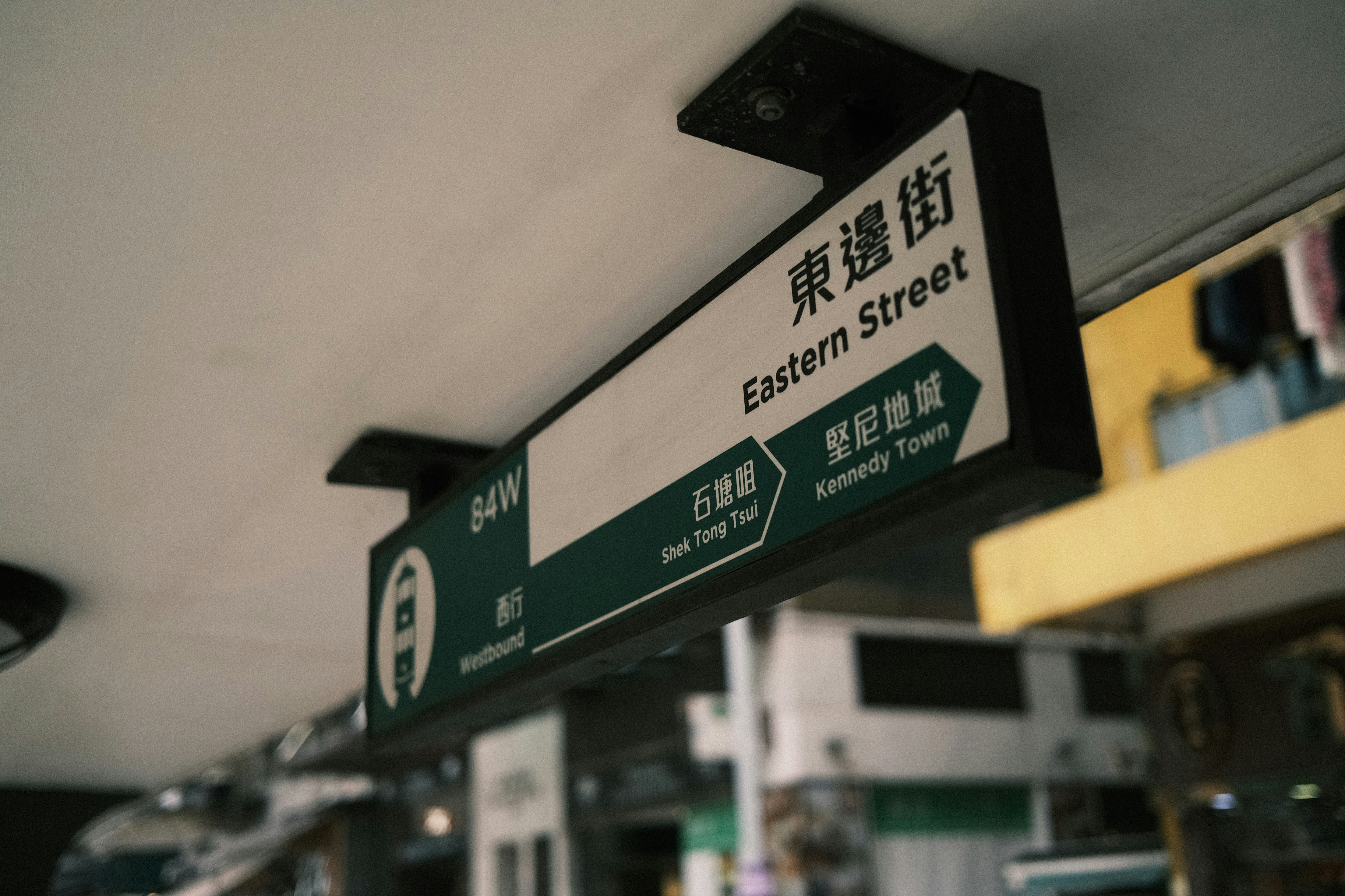a green and white street sign hanging from a ceiling