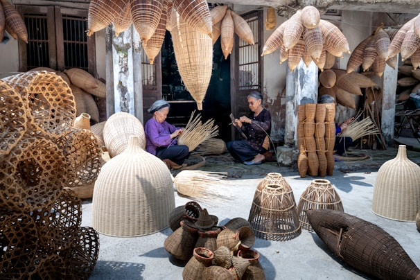a woman sitting on the ground surrounded by baskets
