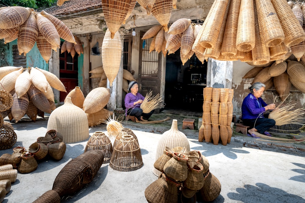 a woman sitting on the ground surrounded by baskets