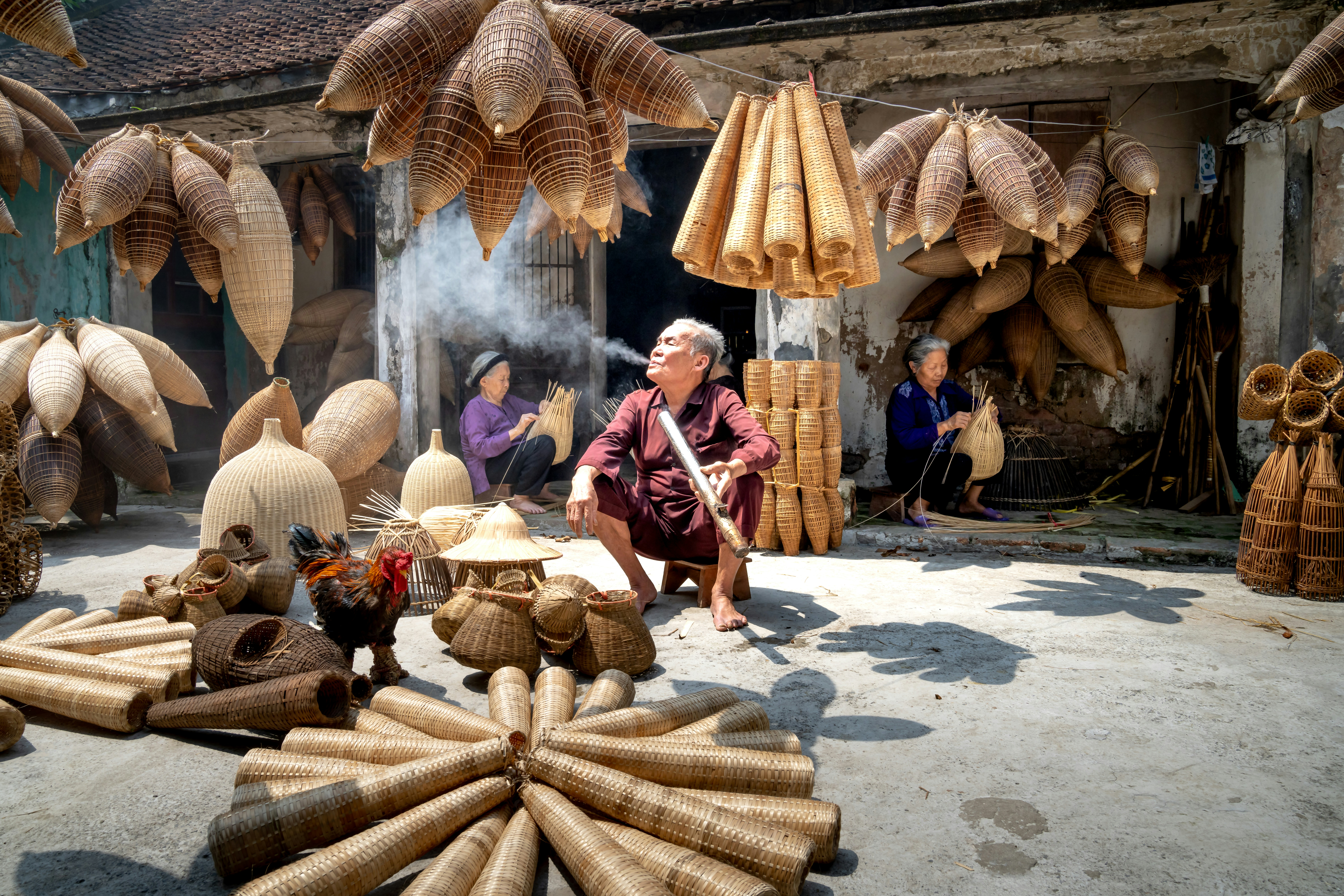a woman sitting on a pile of bamboo sticks