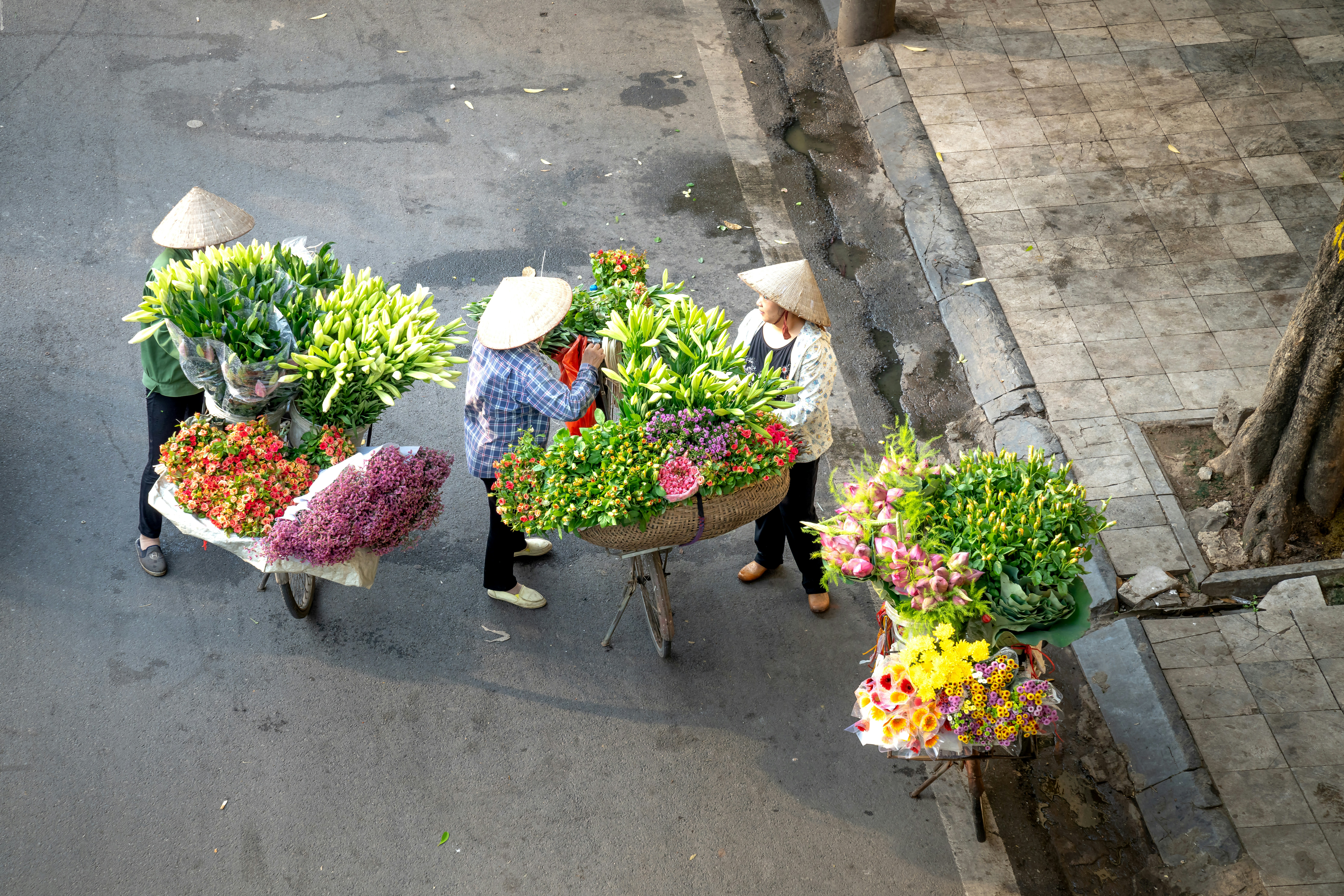 a group of people walking down a street carrying flowers
