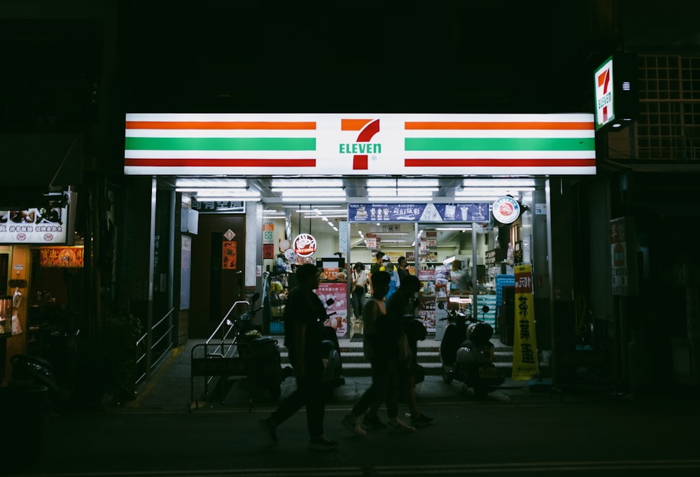 a group of people walking in front of a gas station