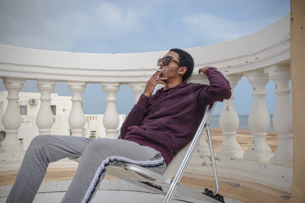 a man sitting in a chair talking on a cell phone