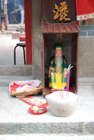 A peaceful shrine adorned with incense and spiritual tokens beside a window.