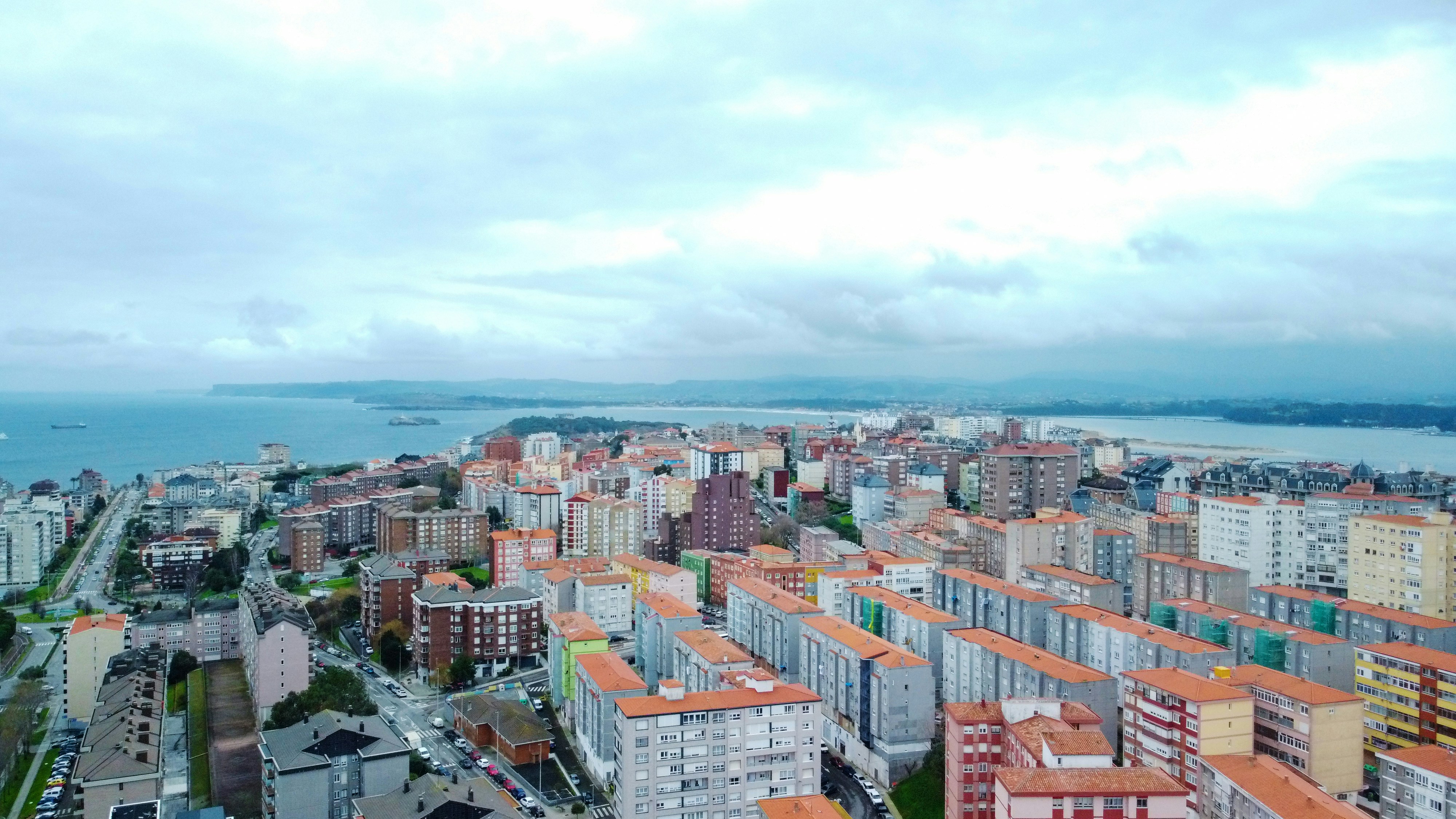 an aerial view of a city with a body of water in the background