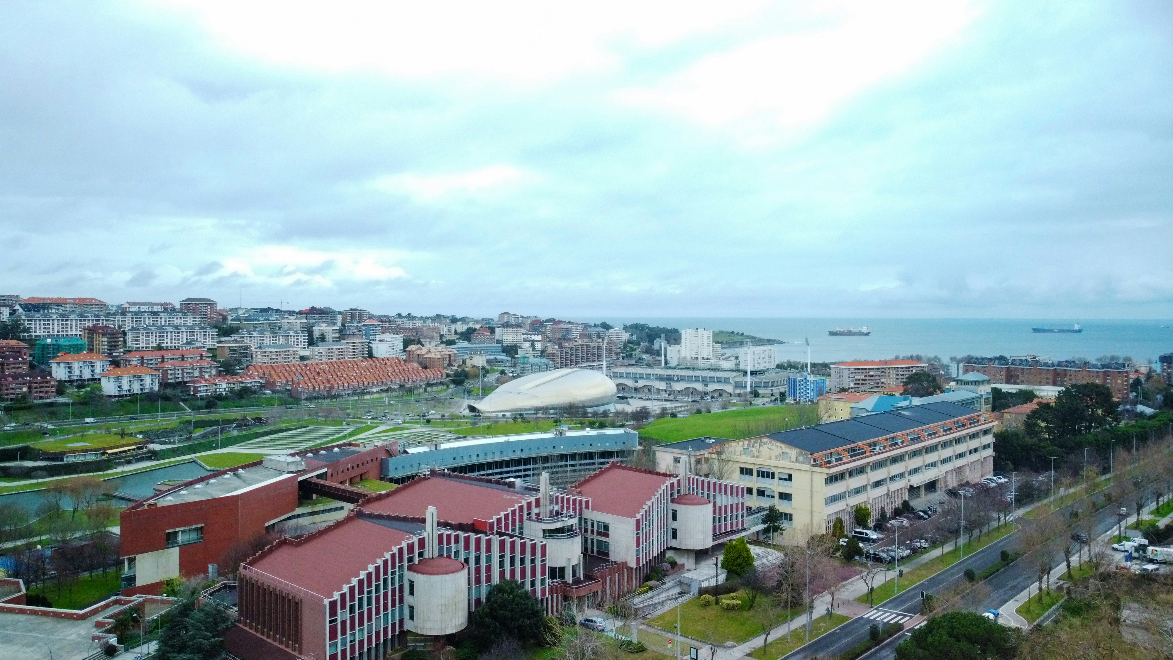 an aerial view of a city with a body of water in the background