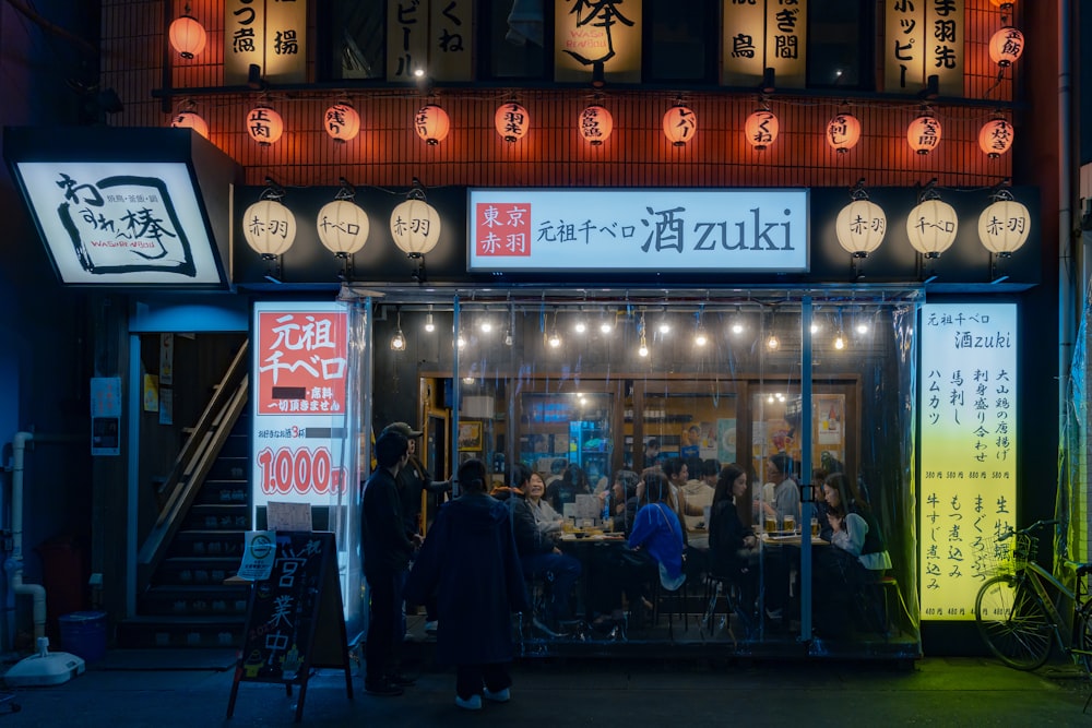 a group of people standing outside of a restaurant