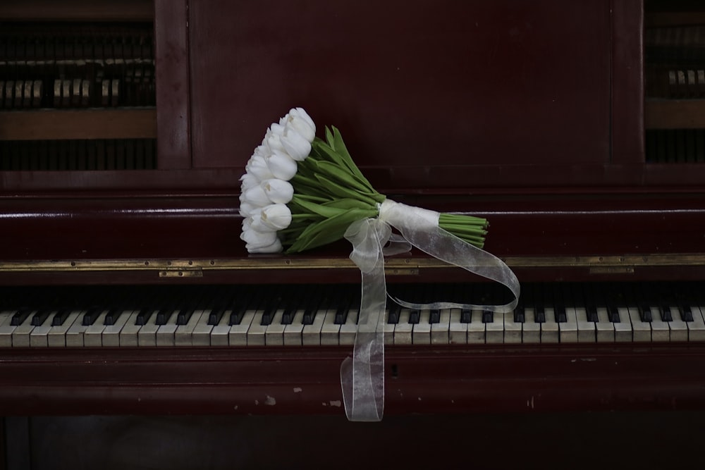a bouquet of flowers sitting on top of a piano