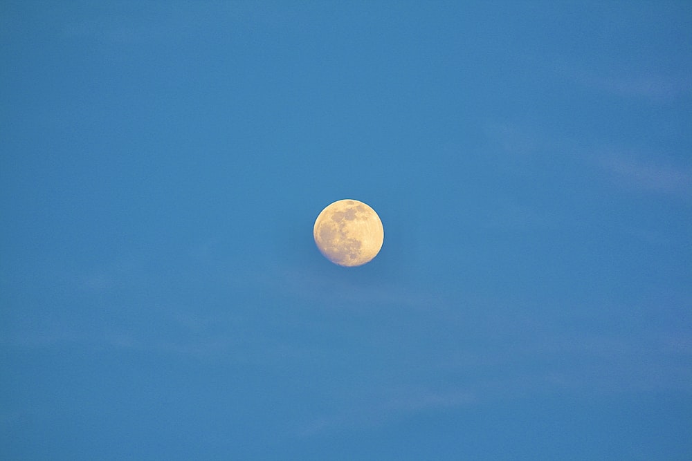 a full moon in a clear blue sky