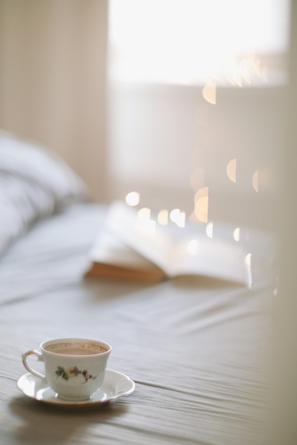 a cup of coffee sitting on top of a bed