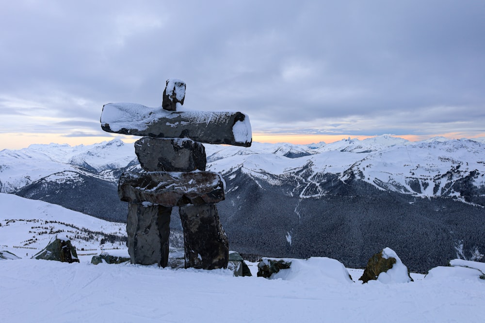 a statue of a man holding a snowboard on top of a snow covered mountain