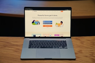 a laptop computer sitting on top of a wooden table