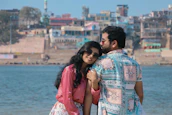 a man and woman standing next to each other near a body of water
