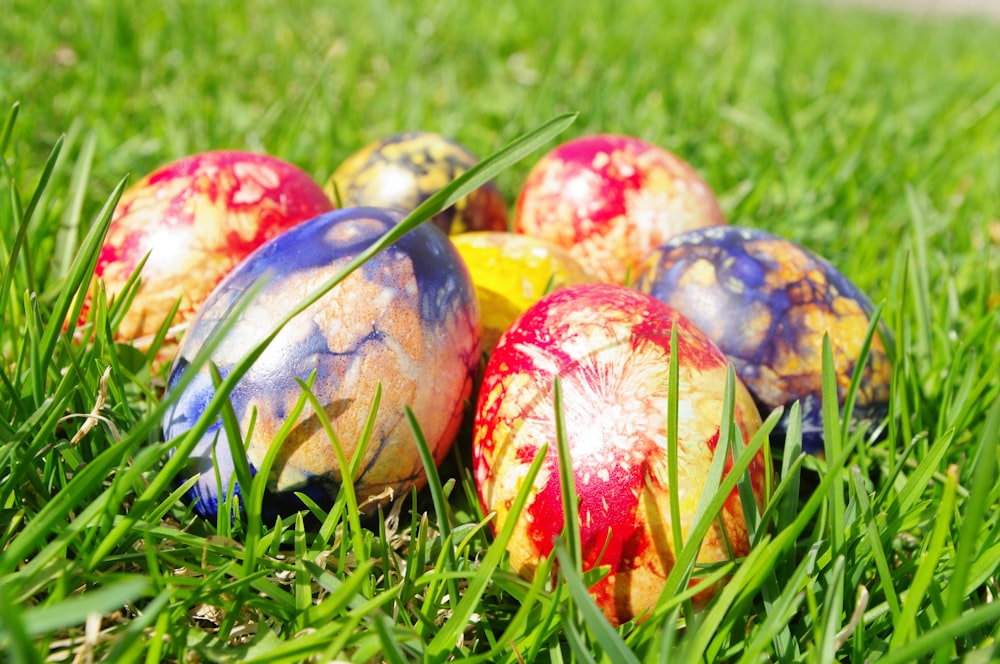 a group of painted eggs sitting in the grass