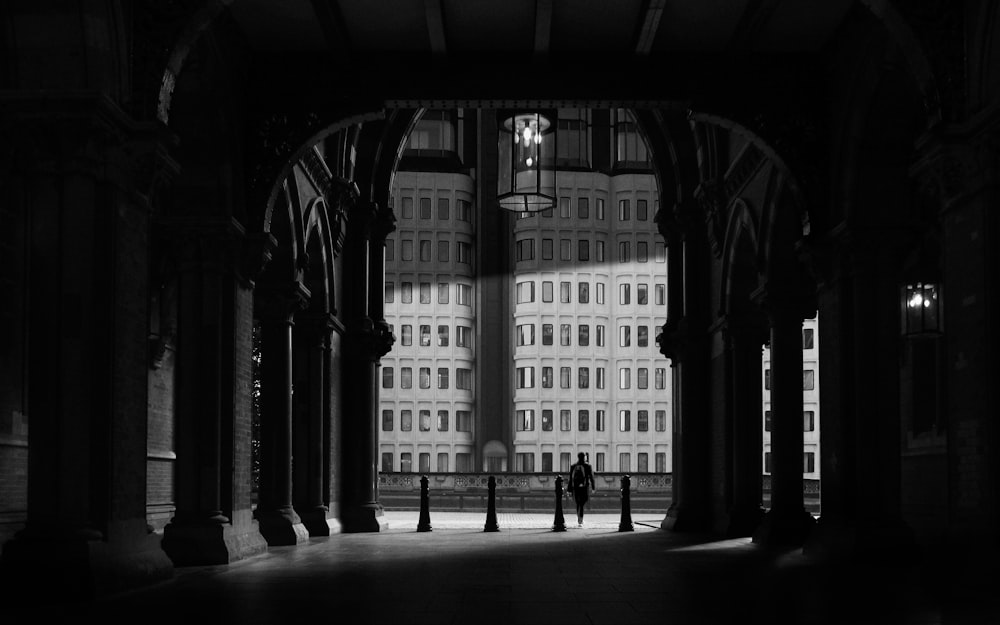 a black and white photo of two people standing in an archway